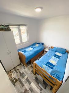a bedroom with two beds and a refrigerator at Kuća za odmor Drina in Zvornik +33 photos