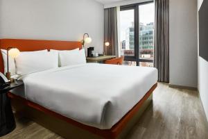 a large bed in a hotel room with a large window at The George At Columbia Harlem, Tapestry Collection By Hilton in New York