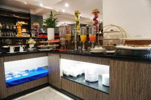 a restaurant with a counter with plates of food at Essence Hotel-Phnom Penh in Phnom Penh