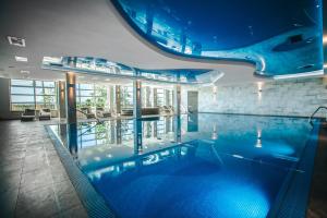 a large swimming pool in a building with a swimming pool at Hotel Radocza Park Business in Radocza