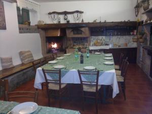 a dining room with a table and chairs and a fireplace at Agriturismo Il Selvello in Montemassi