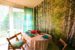 a dining room with a table with chairs and a window at Apartament Niebieskie Narie in Kretowiny +18 photos