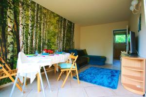 a living room with a table and chairs and a couch at Apartament Niebieskie Narie in Kretowiny