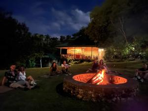 a group of people sitting around a fire pit at night at OM Horizon Ecoresort in Tocdoc