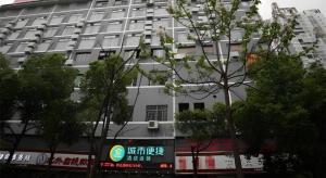 ein großes weißes Gebäude mit Bäumen davor in der Unterkunft City Comfort Inn Hengyang Dayang Department Lianhu Plaza in Hengyang