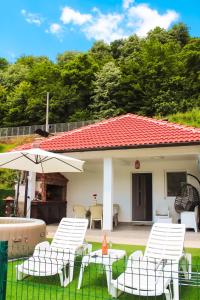 a group of chairs and an umbrella in a yard at Kuća za odmor Drina in Zvornik