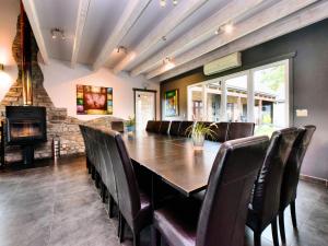 a dining room with a table and chairs and a fireplace at Beautiful villa with heated outdoor pool in Manhay