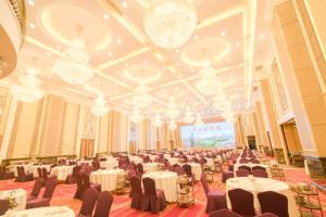 a banquet hall with white tables and chairs and chandeliers at King Century Hotel in Zhongshan +129 photos