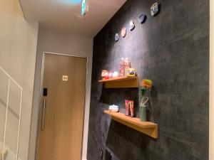 Un baño con estantes en una pared negra. en I GO Hotel, en Tokio