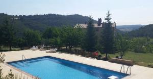 a large swimming pool in front of a house at Les Muntades in Jorba