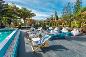 eine Reihe von Liegestühlen neben einem Swimmingpool in der Unterkunft Mossview Resort in Khao Kho
