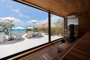 a house with a view of the ocean from a deck at Haimurubushi in Kohama
