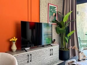 a living room with a flat screen tv on a entertainment center at Qoople Excellence apartments by the sea in Alanya