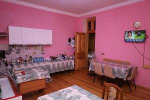 a room with pink walls and tables and chairs at Farid HOSTEL in Ganja