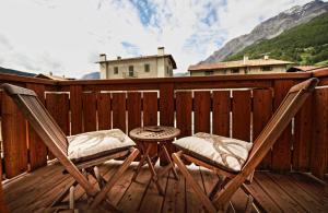 une paire de chaises et une table sur une terrasse dans l'établissement Appartamento Zepp, à Bormio