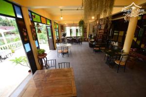 a restaurant with tables and chairs in a room at River Jam Amphawa in Amphawa +85 photos