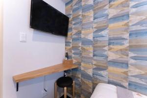Una habitación con una cama y un televisor en la pared. en I GO Hotel, en Tokio 20 fotos más