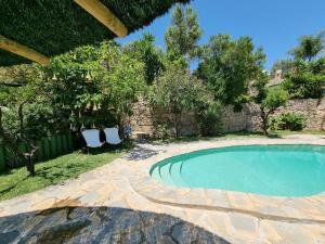 a swimming pool with two chairs in a yard at Casa rural en el Parque Natural de los Alcornocales in Jimena de la Frontera