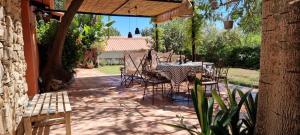 a patio with a table and chairs under an umbrella at Casa rural en el Parque Natural de los Alcornocales in Jimena de la Frontera +12 photos