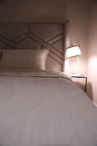 a bedroom with a white bed with a lamp at Quite and cozy studio in Riyadh
