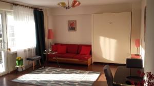 ein Wohnzimmer mit einem roten Sofa und einem Tisch in der Unterkunft Climate of the 60's in Krakau