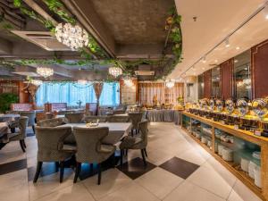 a restaurant with tables and chairs and chandeliers at Overseas Chinese Hotel in Zhuhai