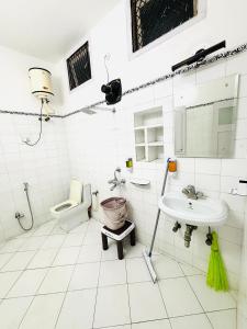 a white bathroom with a sink and a toilet at Modern 4 BHK in Hyderabad