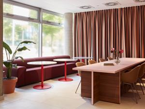 a lobby with a couch and tables and a window at Numa Hamburg St Georg in Hamburg