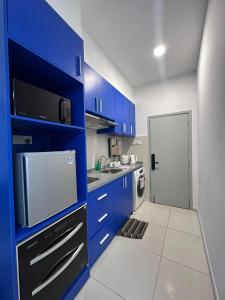 eine Küche mit blauen Schränken und einem weißen Boden in der Unterkunft reStary room 2 in Kota Kinabalu