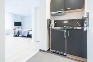 a kitchen with a sink and a stove at Boutique Apartments am Stadtgarten in Freiburg im Breisgau