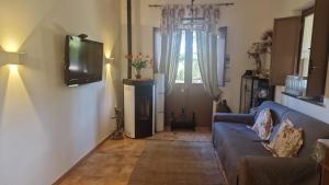 a living room with a couch and a television at La casa di Giulia in Bronte +20 photos
