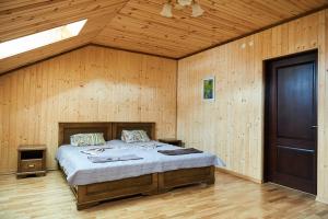 een slaapkamer met een bed in een houten kamer bij Panskyi Kut in Boekovel