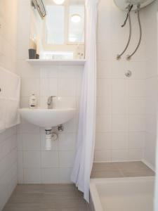 a white bathroom with a sink and a shower at Apartment Ana in Pula