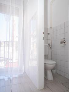a white bathroom with a toilet and a window at Apartment Ana in Pula