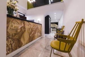 a lobby with yellow chairs and a large painting on the wall at SU29 Boutique Hotel in Valletta