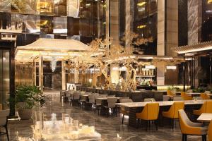 a restaurant with tables and chairs in a building at Hotel Okura Manila at Newport World Resorts in Manila