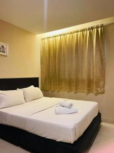 a bedroom with a bed with two towels on it at Blossom hotel in Kota Kinabalu