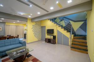 a living room with a blue couch and a staircase at Villa near Vagator Beach in Bardez