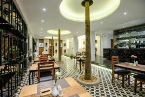 un restaurant avec des tables et des chaises et un arbre au milieu dans l'établissement K.K inn Boutique Siem Reap, à Siem Reap
