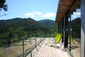 a deck with yellow chairs and a view of mountains at Retiro Da Arminda in Canedo