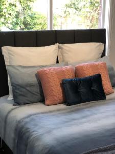 un grupo de almohadas sentado encima de una cama en Gisborne large family home with wifi, en Gisborne