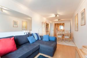 a living room with a blue couch and a dining room at Seaspray in Saint Mawes