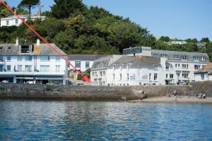a group of buildings on the shore of a body of water at Seaspray in Saint Mawes