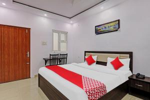 Un dormitorio con una cama grande con almohadas rojas. en Hotel O A-One Inn, en Bijnaur