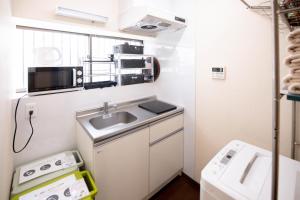 a small kitchen with a sink and a microwave at 夏様楽善 Historic Kyoto Machiya,Experience Japanese Lifestyle Comfortably in Kyoto +51 photos