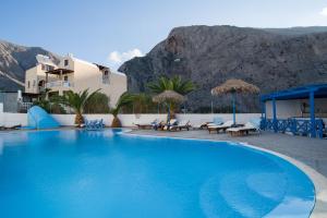 a large swimming pool with a mountain in the background at Studio Letta in Perissa