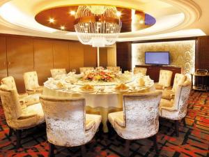 a dining room with a white table and chairs at Dalian Southern Airline Pearl Hotel in Dalian +29 photos