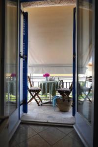 an open door to a patio with a table and chairs at Mania Rooms and Studios in Poros