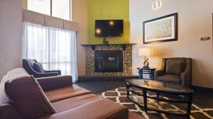 a living room with a couch and a fireplace at Best Western Windsor Inn in Dumas