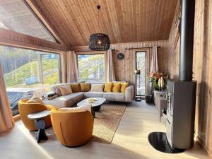 a living room with a couch and chairs and a tv at Spacious lodge with sauna, ski centre in Noresund